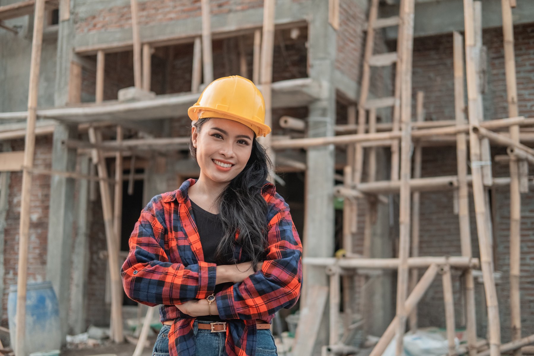 Beautiful Female Asian Contractors Wearing Safety Helmets with Crossed Hands